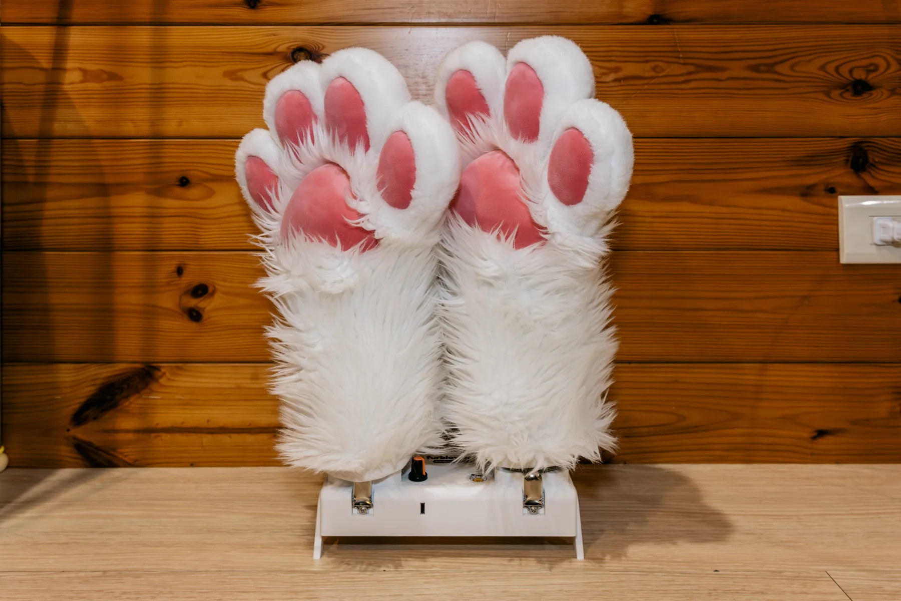 FurBlower PAWS TURBO 放在桌上架上並套上兩隻白色毛手